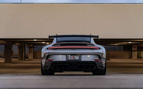 Szczegółowe zbliżenie na sportowy samochód Porsche 911 GT3 RS, charakteryzujący się... 7680x4800