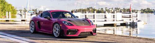 Luksusowy sportowy samochód marki Porsche zaparkowany na nowoczesnej ulicy w mieście... Dual UHD