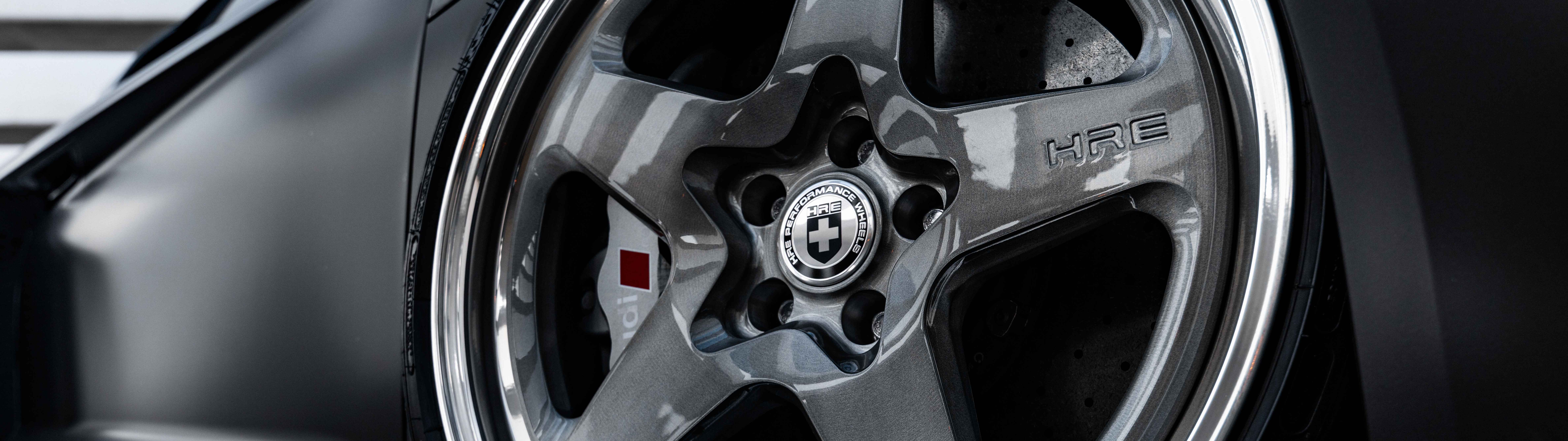 Profesjonalne zdjęcie wykonane z bliska, przedstawiające elegancką, luksusową limuzynę Audi z polerowanym metalicznym wykończeniem.