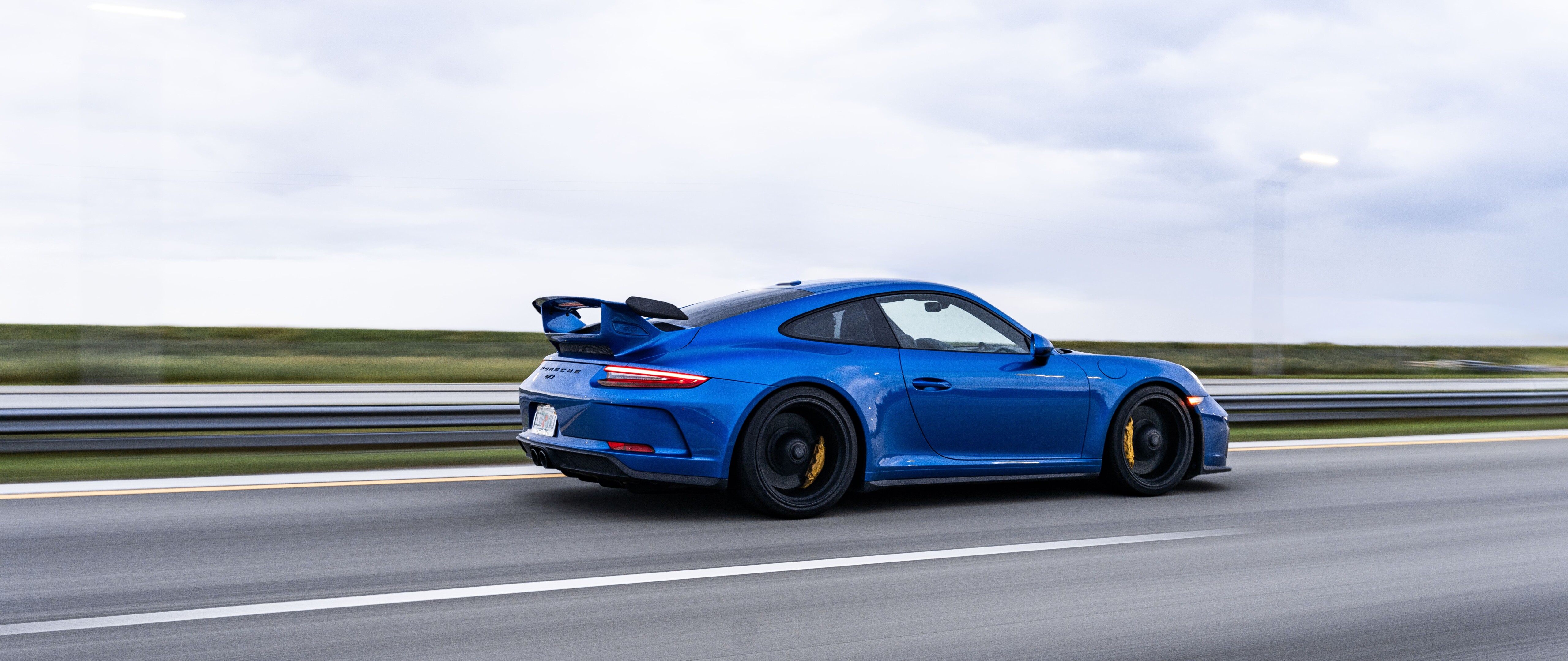 Wysokowydajny sportowy samochód Porsche GT3 RS, wyposażony w aerodynamiczne elementy typowe dla samochodów wyścigowych.