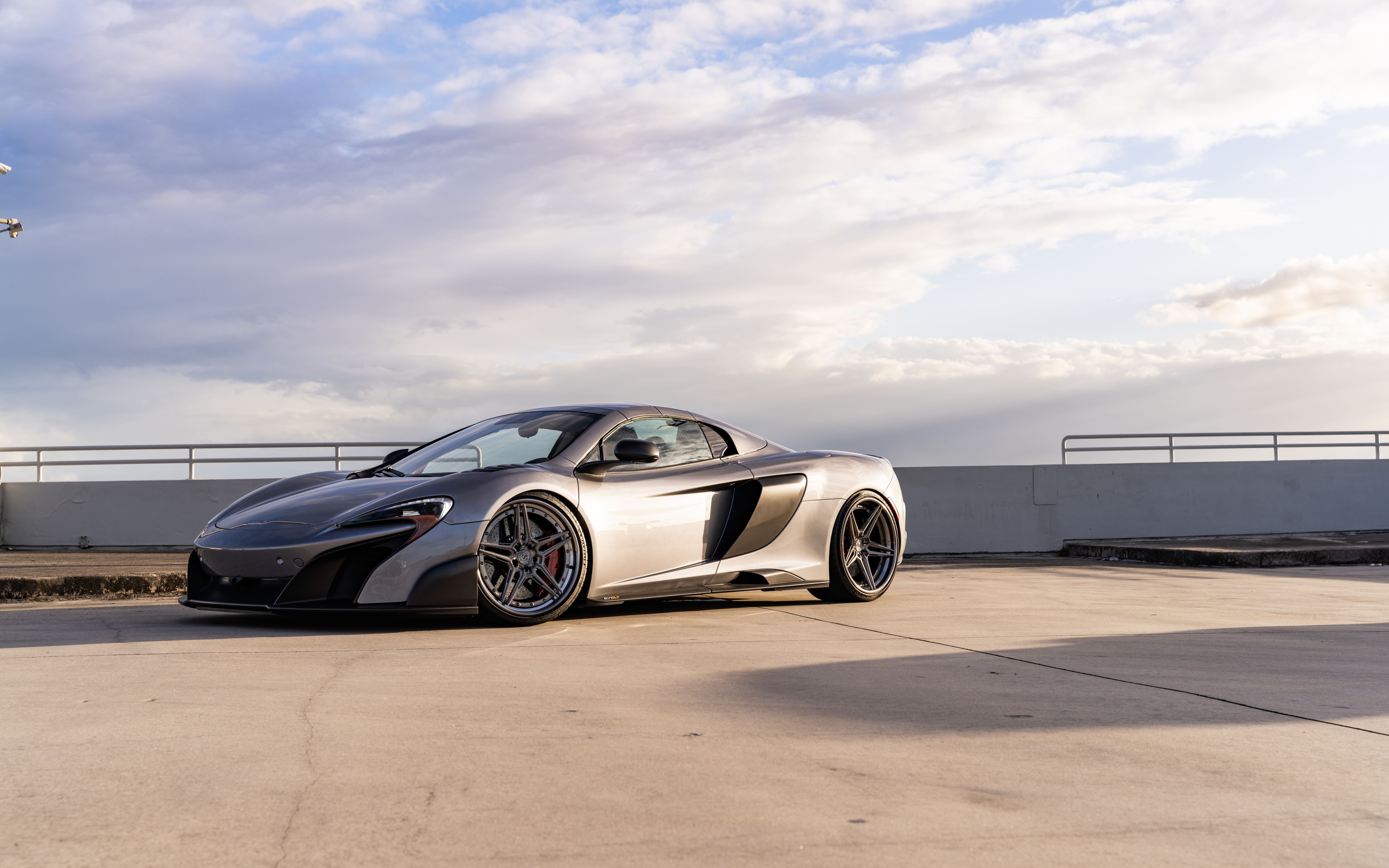 Wysokowydajny samochód sportowy marki McLaren, charakteryzujący się aerodynamiczną sylwetką i eleganckim metalicznym wykończeniem.