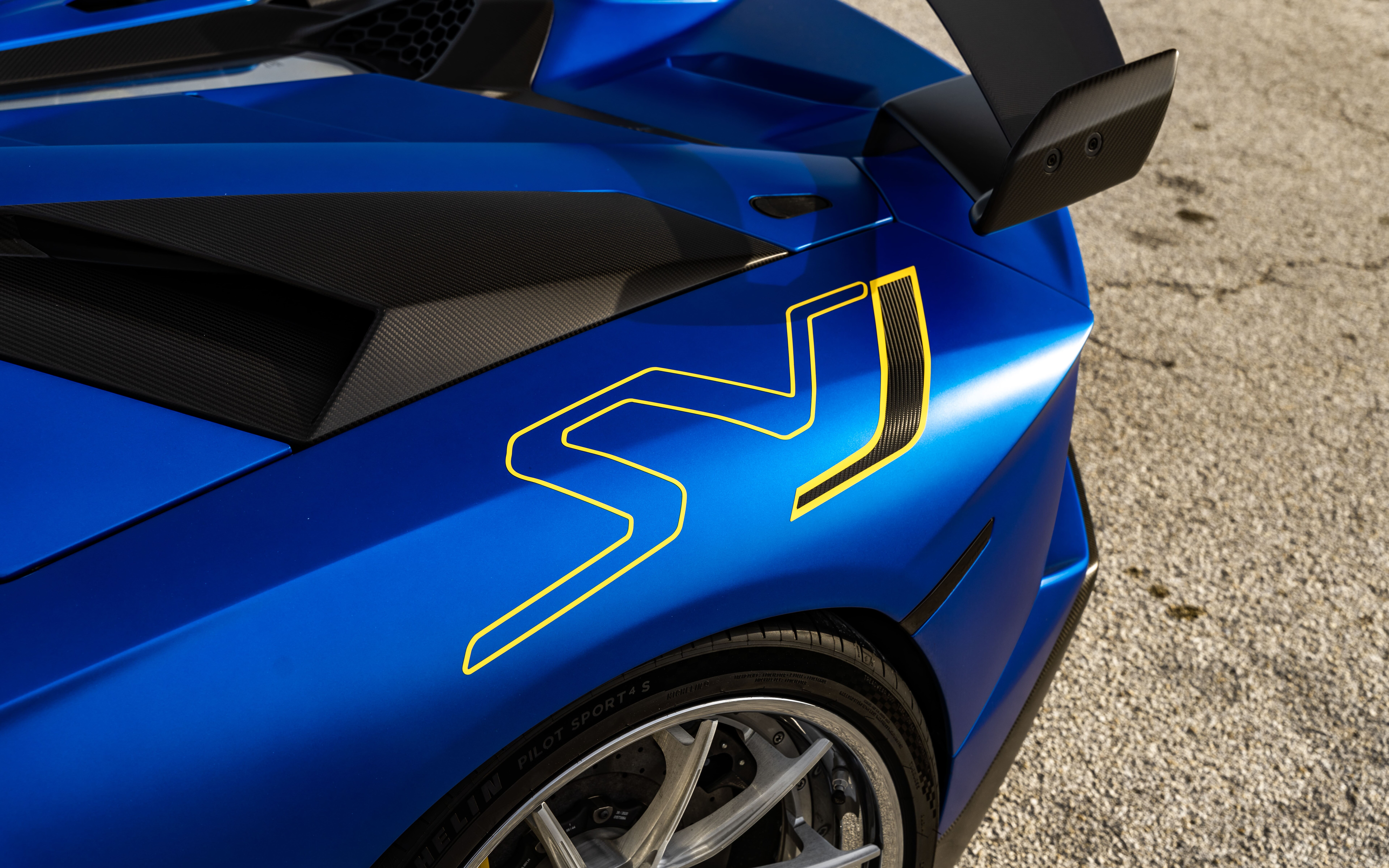 Elegancki i potężny Lamborghini Aventador SVJ, charakteryzujący się charakterystyczną, aerodynamiczną sylwetką i agresywnym przednim pasem.