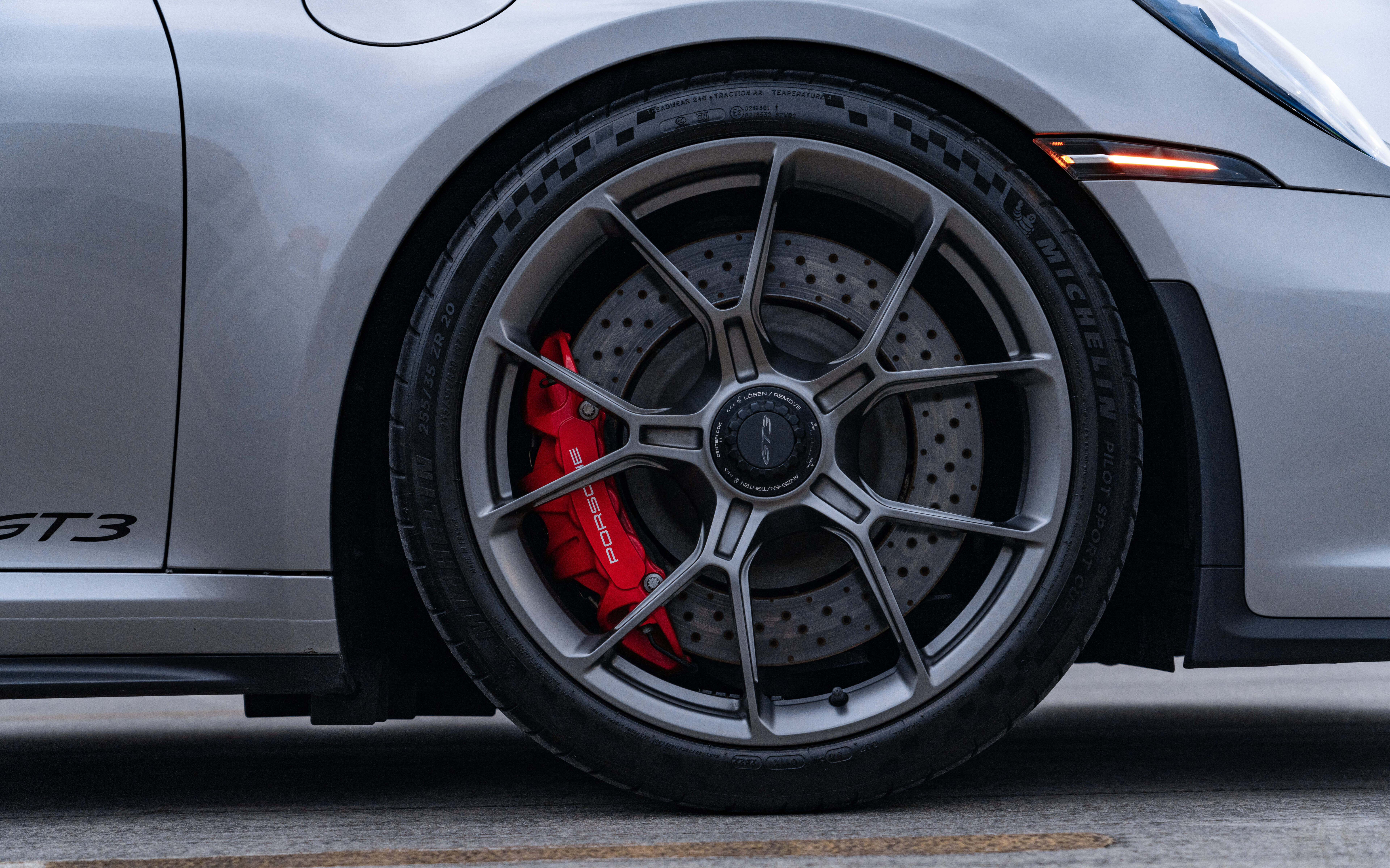 Wysokowydajny samochód sportowy Porsche GT3 RS, charakteryzujący się aerodynamiczną sylwetką i charakterystycznym tylnym spojlerem.