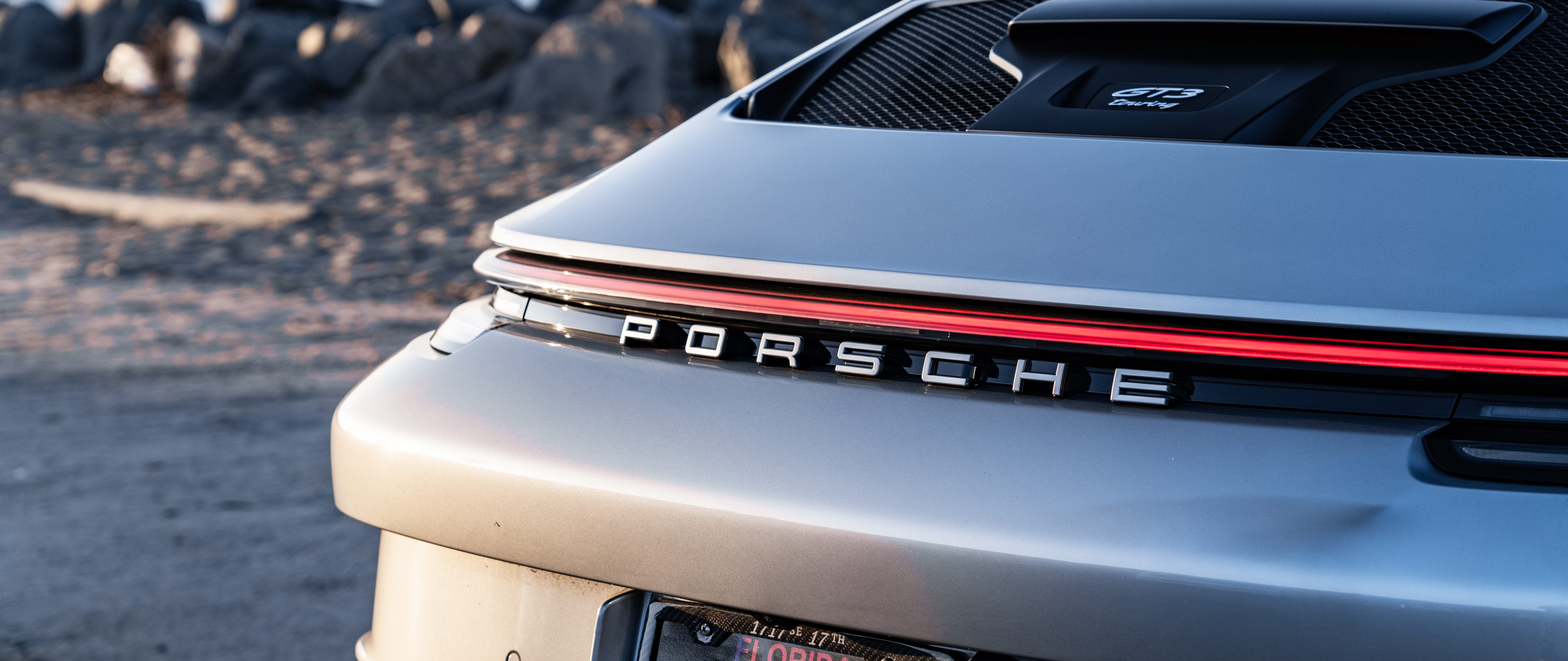 Wysokowydajny samochód sportowy Porsche GT3 RS, charakteryzujący się agresywną stylistyką aerodynamiczną i smukłą sylwetką typową dla samochodów wyścigowych.