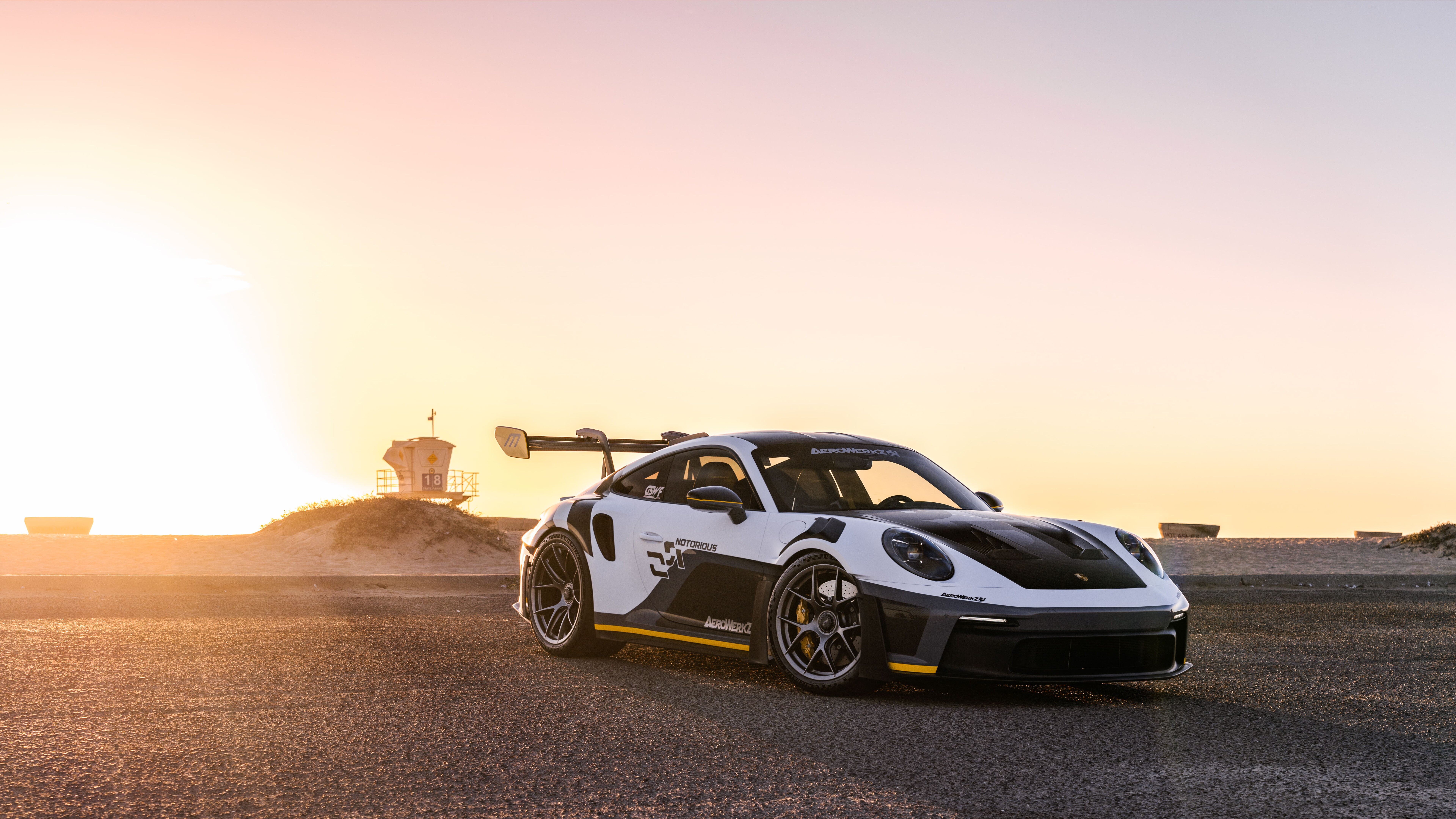 Wysokowydajny samochód sportowy Porsche GT3 RS, charakteryzujący się agresywnym, aerodynamicznym nadwoziem i dużym tylnym spojlerem.